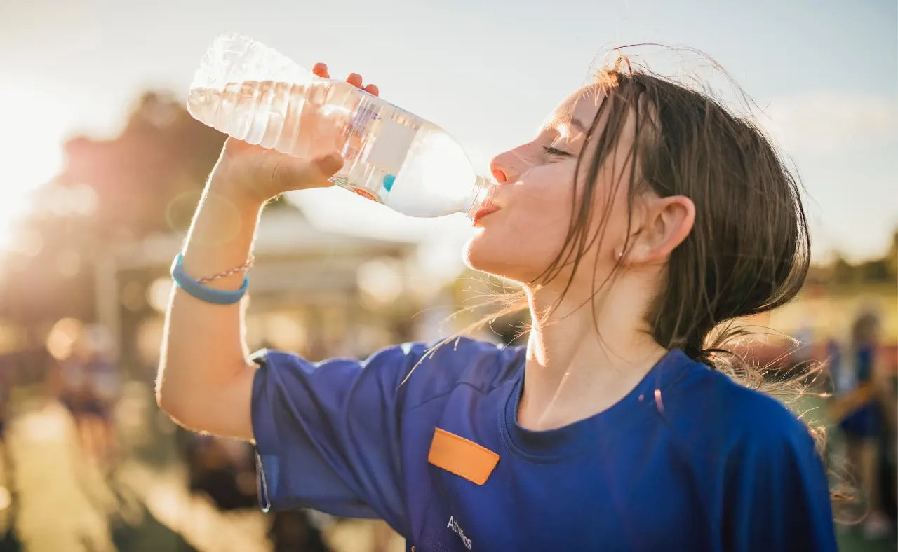 Adolescent athlete hydrating during sport, illustrating safe hydration practices for teenage athletes